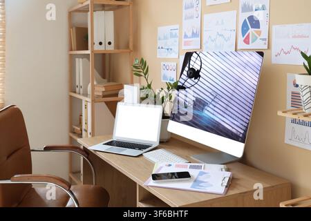 Interior of data scientists office with workplace, diagrams and shelf unit Stock Photo