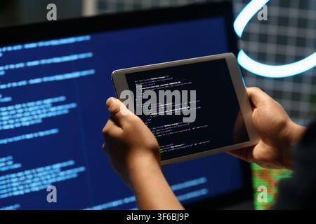 Programmers hands with modern tablet computer in office, closeup Stock Photo