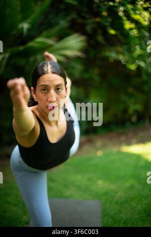 Woman practicing yoga dancer pose in garden Stock Photo
