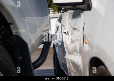 Close-up of damaged white car after traffic collision, showing side impact and body damage. Concept for car insurance claims, vehicle inspection, road Stock Photo
