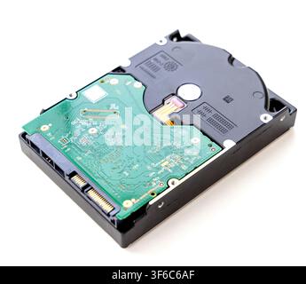 An isolated internal computer hard drive is shown from the bottom perspective, highlighting the green printed circuit board and connection ports Stock Photo