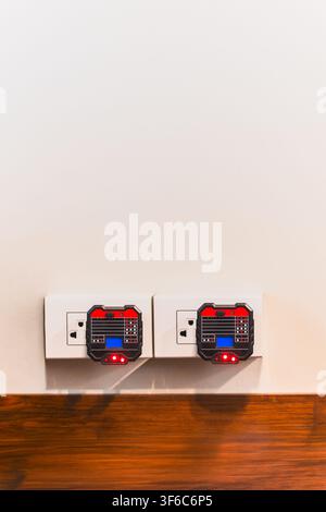 Two digital socket testers plugged into wall outlets to check electrical wiring Stock Photo