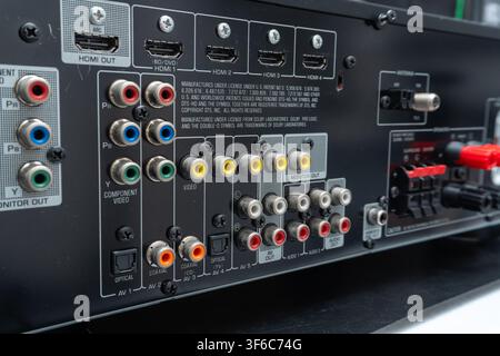 Audio and video ports on a home entertainment receiver. Red, white, yellow, blue, green, and orange connectors visible. RCA, HDMI, and optical audio j Stock Photo
