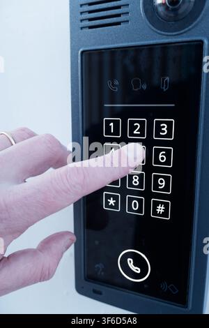 Lisboa, March 13, 2022: Hand pressing numeric keypad on an electronic door entry system. Stock Photo