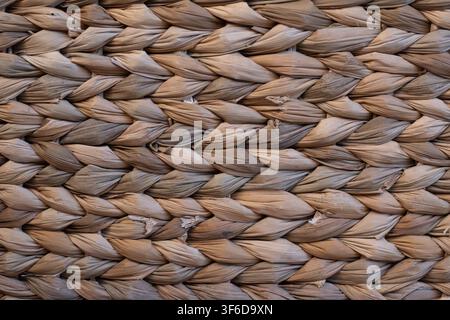 Close up of woven dried palm leaves with a repeating braided pattern, showing natural material, rustic texture and traditional handmade craft. Stock Photo