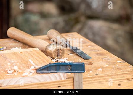 Beautiful shallow depth of field photography of wood shavings and carving tools on a desk Stock Photo