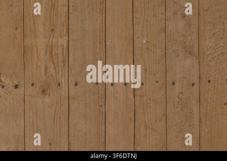 A full frame background of vertical light brown wooden planks with nail marks. Stock Photo