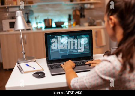 Female programmer works from home on malicious software intended to breach a protected firewall during a late-night cyberattack. Stock Photo