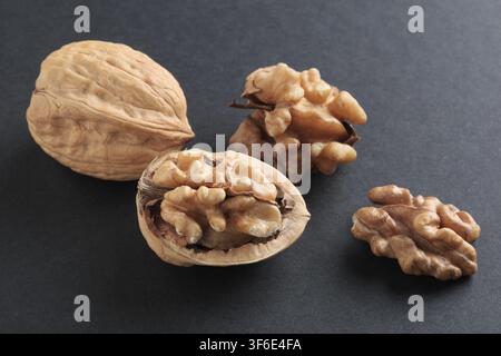Close up of cracked walnuts on black background Stock Photo
