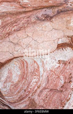 Abstract close-up of layered pink and white sandstone with weathered swirls, cracks, and mineral textures at Yant Flat in the Candy Cliffs, Utah deser Stock Photo