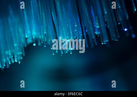 Abstract close-up of glowing blue fiber optic strands against a dark background, representing high-speed data transmission, digital communication, int Stock Photo