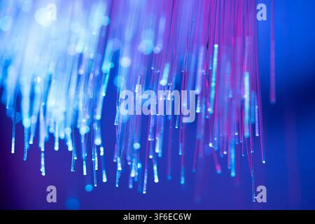 Abstract fiber optic technology background featuring glowing blue and purple light strands, luminous endpoints, and soft bokeh. Ideal for data transmi Stock Photo