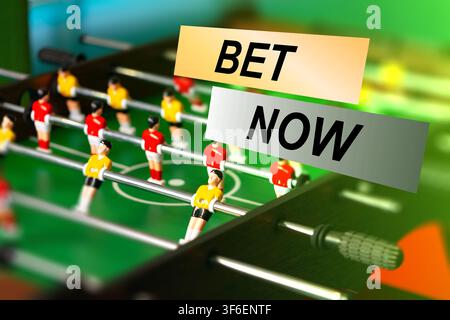 Sport betting with foosball table in action featuring players in yellow and red moving on the field Stock Photo