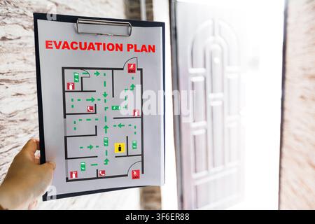 Emergency evacuation plan displayed on wall near exit door Stock Photo