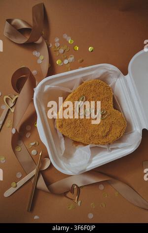 Heart shaped bento cake with love sign in take away white container on beige background, valentines day concept Stock Photo