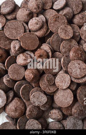 Background of dark chocolate callets, drops, and chips for pastry making and baking Stock Photo