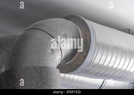 A detailed view of a joint between a rigid insulated pipe and a flexible metallic conduit for air circulation systems Stock Photo