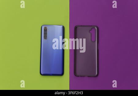 Smartphone with a silicone protective cover on green purple background. Top view Stock Photo