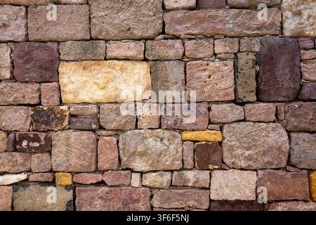 Rustic Stone Wall Texture Background with Ancient Multi Colored Blocks Stock Photo