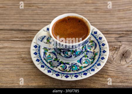 Traditional Turkish Coffee in Patterned Ceramic Cup on Rustic Wooden Table Stock Photo