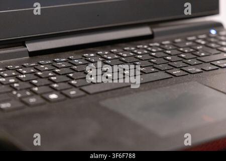 Detailed perspective of a modern laptop's input devices, highlighting the keyboard layout and smooth trackpad surface Stock Photo