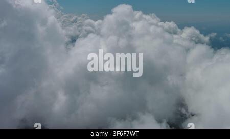 Flying through white clouds over sea Stock Photo