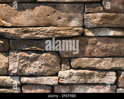Natural stacked stone wall cladding texture with rough surface background Stock Photo