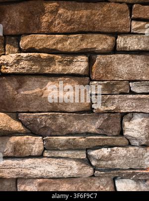 Vertical brown stacked stone wall background texture with detailed rough masonry Stock Photo