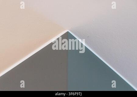 A minimalist abstract image featuring sharp lines and soft transitions between beige, gray, and teal surfaces, creating a sense of depth and simplicit Stock Photo
