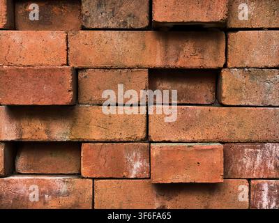 Red brick wall texture with uneven stacked pattern, industrial clay brickwork background. Stock Photo
