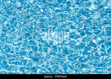 Abstract pattern of light and shadow dancing on the rippling water of a clean swimming pool, creating a serene and refreshing visual Stock Photo