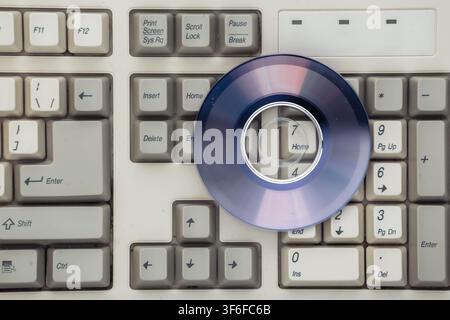 Retro electronics, pc technology 90s. PC keyboard and cd. Top view Stock Photo