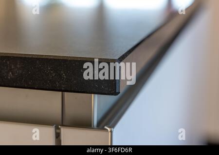 Detailed view of a polished black granite surface and its beveled edge, showcasing the texture and material quality Stock Photo