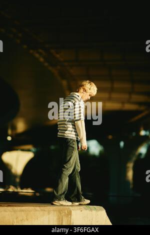 Man Walking Outdoors under Bridge in City Stock Photo