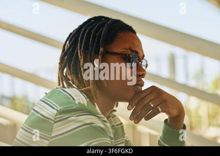 Black Man with Dreadlocks Listening to Music Outdoors Stock Photo