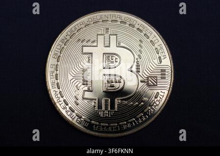 Physical Bitcoin themed token with cryptocurrency symbol on dark background Stock Photo