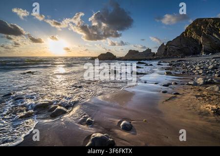 Sun setting over the Sandymouth Bay horizon Cornwall in August Stock Photo