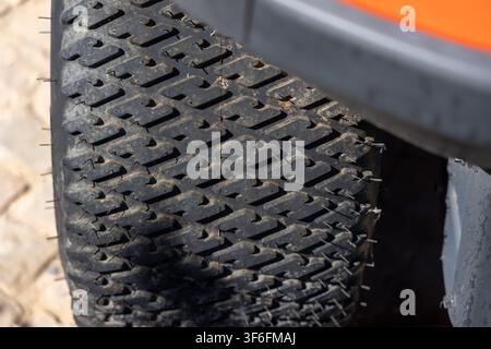 Detailed view of a heavily used tire's aggressive tread pattern, showing signs of abrasion and dirt accumulation Stock Photo