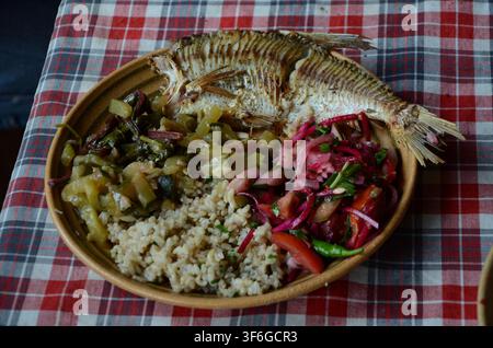Fried bream served with vegetables, grain side dish and fresh salad in Bárdudvarnok, Hungary... Stock Photo