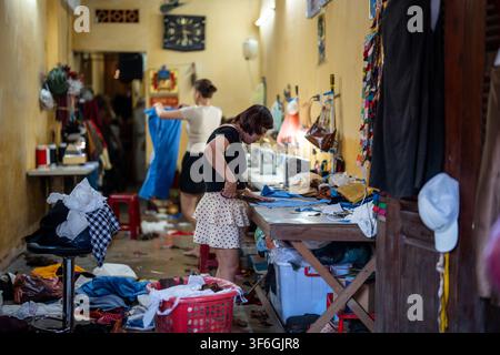 Creative working process at private sewing atelier, professional woman seamstress cutting fabric. Stock Photo