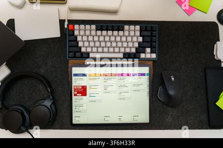 Software Engineer Development Workspace Top View Flat Lay Setup. Overhead view of a modern tech desk setup with a digital tablet displaying a project Stock Photo