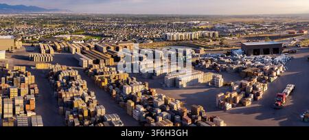 Aerial view of a large industrial yard filled with organized pallets of construction materials including bricks, pavers, and cinder blocks with a truc Stock Photo
