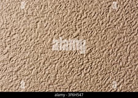 beige textured surface background, rough bumpy pattern and grainy tan finish, full frame close-up, industrial material or wall design concept Stock Photo