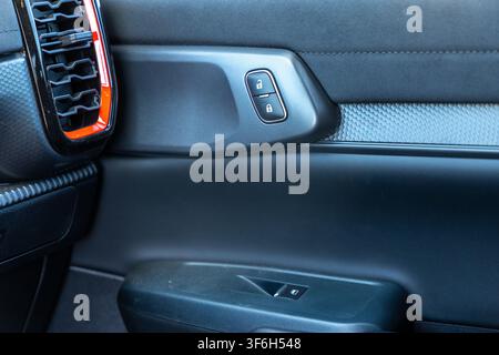 Close-up view of a vehicle's interior door panel showcasing the lock buttons and window switch Stock Photo