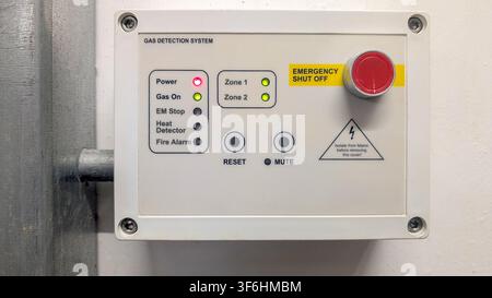 Commercial gas detection control panel with emergency emergency stop button installed on a building services plant room wall for monitoring gas safety Stock Photo