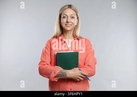 Teacher with notebooks and pen on light grey background Stock Photo