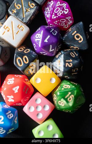 Studio shot from above of numerous gaming accessories and colorful dice on dark background Stock Photo
