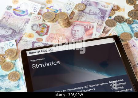 BoE Bank of England website with pound sterling notes and coins in the background Stock Photo