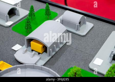 Model of reinforced concrete protective shelter made of key blocks created 3D printer from molten plastic. Prototype grain silo or industrial tank made of plastic and other infrastructure. 3D printing Stock Photo