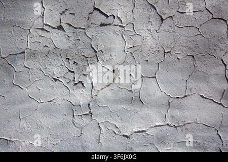 Abstract Background of Cracked and Peeling Gray Paint on Weathered Concrete Wall Texture Stock Photo
